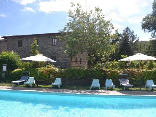 un grupo de sillas y sombrillas junto a una piscina en Serene Apartment with Garden Pool Terrace Deckchairs en Lucolena in Chianti