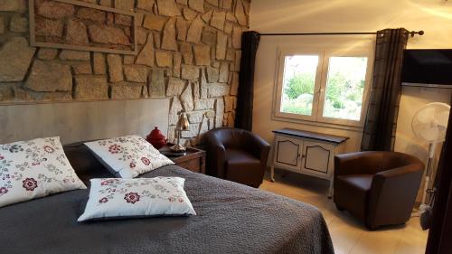 a bedroom with a bed and two chairs and a window at Résidence Di A Serra in Calvi