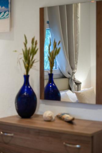 two blue vases sitting on a dresser in front of a mirror at Caretta Village in Toroni