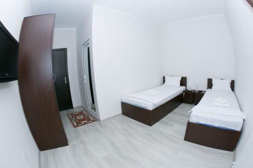 Habitación pequeña con 2 camas y espejo. en Casa Stefan Galati en Galaţi