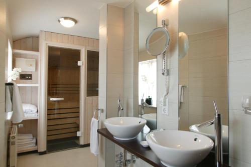a bathroom with two sinks and a mirror at Landhaus Wolf - wir freuen uns in Schwäbisch Hall