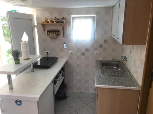 a small kitchen with a sink and a window at Apartman Sanjković in Rovinjsko Selo