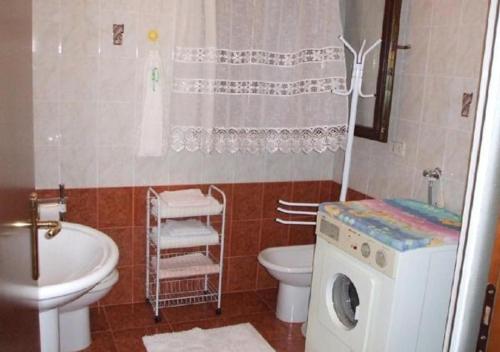 a bathroom with a washing machine and a toilet at Casa Vacanze All'Orizzonte Duino in Duino