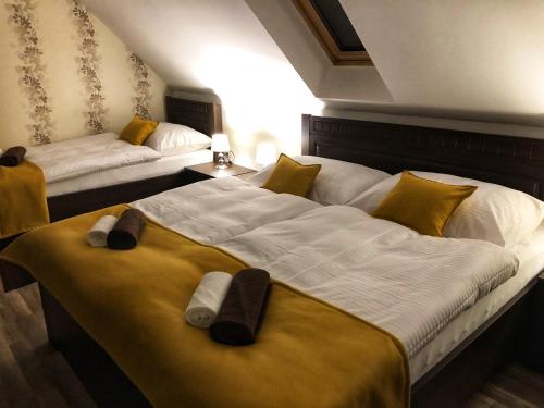 twee bedden in een hotelkamer met handdoeken erop bij Villa Rustica in Bešeňová