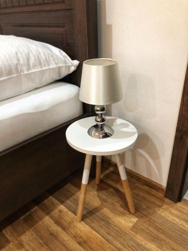 a small table with a lamp on it next to a bed at Villa Rustica in Bešeňová