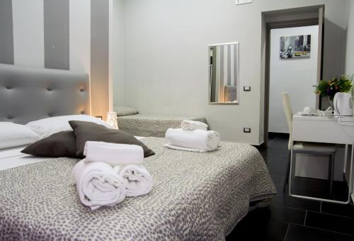 ナポリにあるB&B Napoli Binario 1のベッドルーム1室(ベッド1台に白いタオル2枚付)