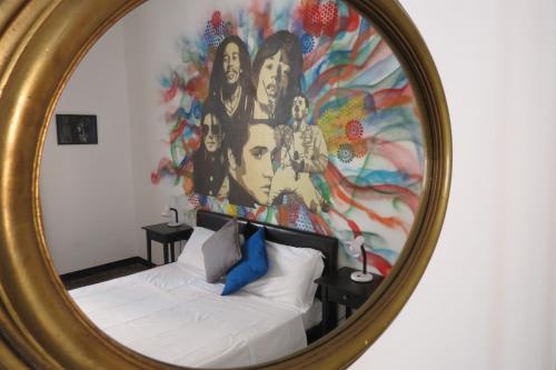 a mirror reflecting a bed in a room with a painting at Leone X Genova Affittacamere in Genova
