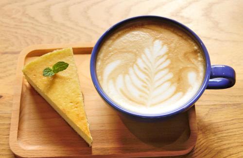 a cup of coffee and a piece of food on a tray at 洛阳一见客栈 in Luoyang