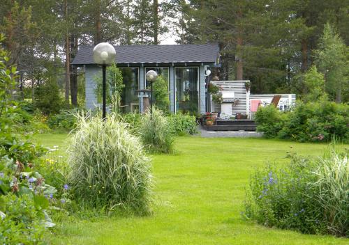 a small house in a garden with a lawn at Lomakylä Atimo in Alakitka