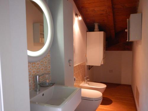 a bathroom with a sink and a toilet and a mirror at B&B Via Punta 8 in Bologna