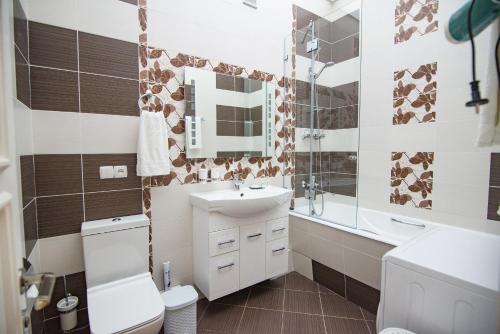 y baño con lavabo, aseo y espejo. en Art Apartment, en Tashkent