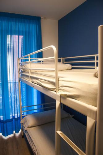 a bunk bed in a room with blue walls and windows at Pensión San Fermín in Donostia-San Sebastián