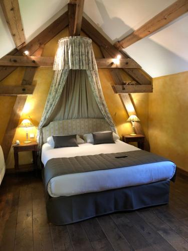 a bedroom with a bed with a canopy at Château de Challanges in Beaune