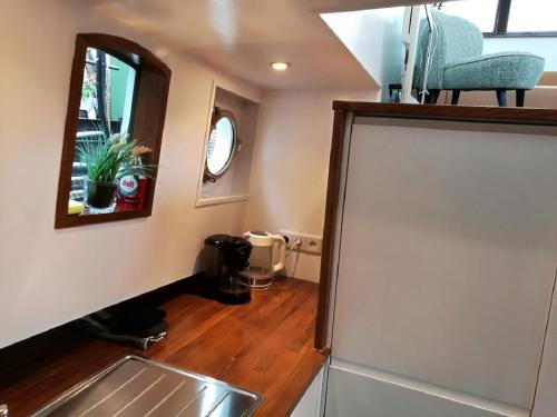 a small kitchen with a sink and a mirror at houseboat Rose in Amsterdam