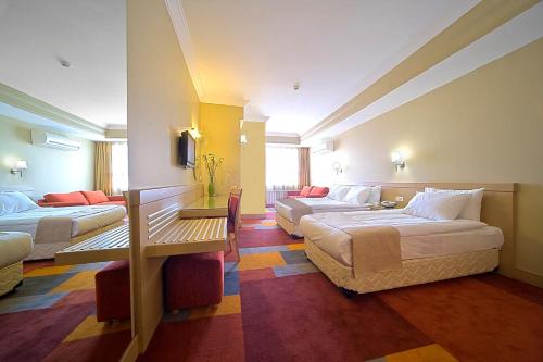 a hotel room with two beds and a table at SV Business Hotel Diyarbakır in Diyarbakır