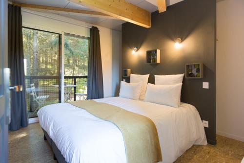a bedroom with a large white bed and a window at Domaine Spalazen Nature in Palazinges