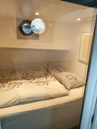a bedroom with a bed and two mirrors at houseboat Rose in Amsterdam