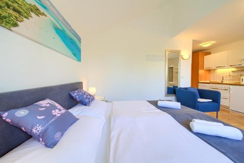 ein Schlafzimmer mit einem großen weißen Bett mit lila Kissen in der Unterkunft Villa Punta in Punat
