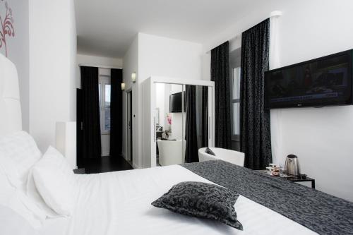 a bedroom with a white bed and a flat screen tv at Sleep Split in Split