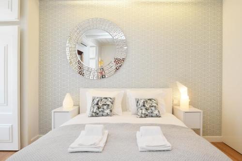 リスボンにあるChiado Luxury Experience - Checkinhomeのベッドルーム1室(壁に鏡付きのベッド1台付)