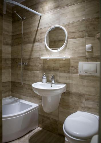 a bathroom with a sink and a toilet and a mirror at VILLA DIANA USTKA to Twój wypoczynek, wyjątkowy klimat zapraszamy in Ustka