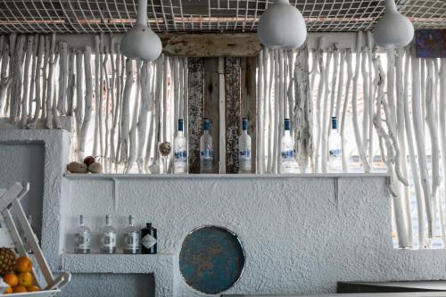 a bunch of bottles on a shelf in a kitchen at Xenios Hotel in Pefkochori