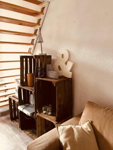 a living room with a couch and a staircase at Unieke stadswoning voor 2 personen met Finse sauna in Apeldoorn