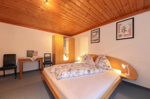 a bedroom with a bed with a wooden ceiling at Pension Hauser in Sankt Jakob in Haus