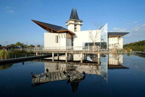 a church with its reflection in a body of water at Árpád nyaralóház in Sarud