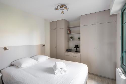 - une chambre blanche avec un lit et des placards blancs dans l'établissement Au Quai Des Pecheurs by Cocoonr, à Saint-Malo