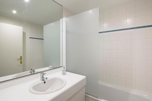 a white bathroom with a sink and a mirror at Au Quai Des Pecheurs by Cocoonr in Saint Malo