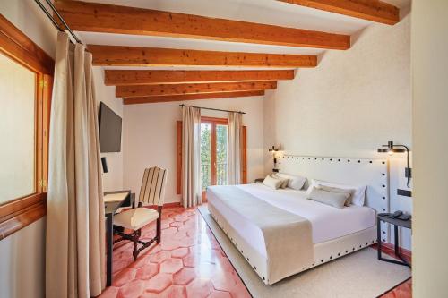 a bedroom with a large white bed and a desk at Virrey Finca Hotel in Inca