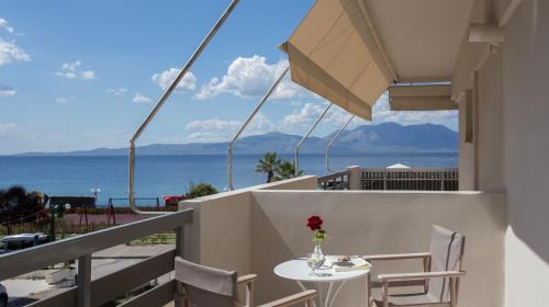 a table and chairs on a balcony with a view of the ocean at Seaside Studios in Áyioi Apóstoloi