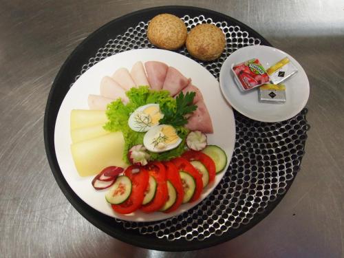 a plate of food with meats and cheese on a table at Zajazd Siodlo Hotel&Restauracja in Kobyla Góra