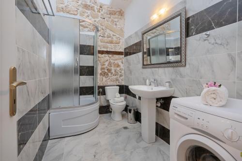 a bathroom with a sink and a washing machine at Casa Di Silvia in Rethymno Town