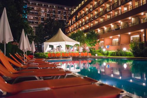 a hotel pool with chairs and a gazebo at Hotel Gladiola Star in Golden Sands
