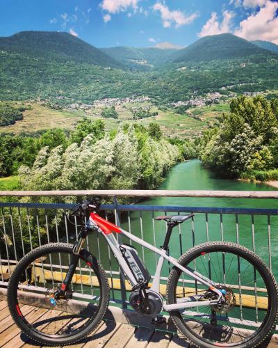 a bike parked on a bridge overlooking a river at B&B Valtellina Mon Amour in Piateda