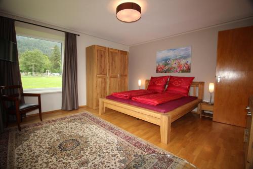 ビショフスヴィーゼンにあるFerienwohnung 1 Gestüt Pfaffenlehenのベッドルーム1室(赤い枕のベッド1台、窓付)