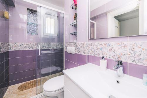 Un baño morado con inodoro y lavabo. en Modern 2BDR apartment-CATHEDRAL VIEW-BEST LOCATION, en Sarajevo