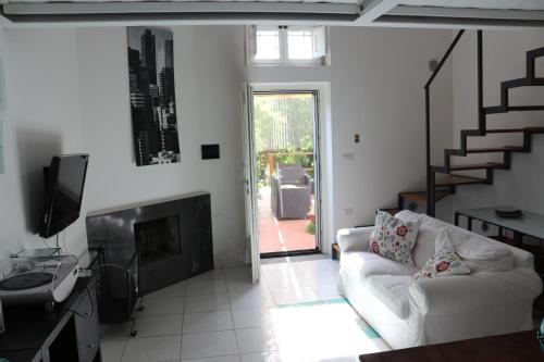 een woonkamer met een witte bank en een open haard bij Desiderio D'Ammore in Corbara
