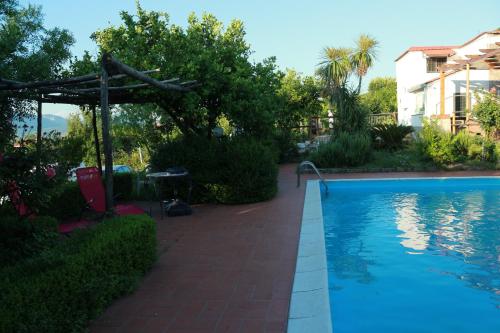 a swimming pool with a pergola next to a house at Desiderio D'Ammore in Corbara