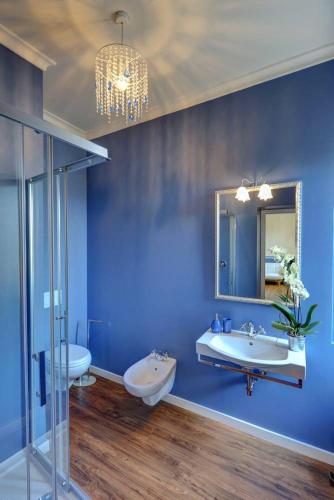 a blue bathroom with two sinks and a mirror at B&B La Contessa in Monfalcone