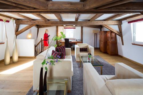 a woman standing in the middle of a living room at Grand Hotel des Bains Kempinski in St. Moritz