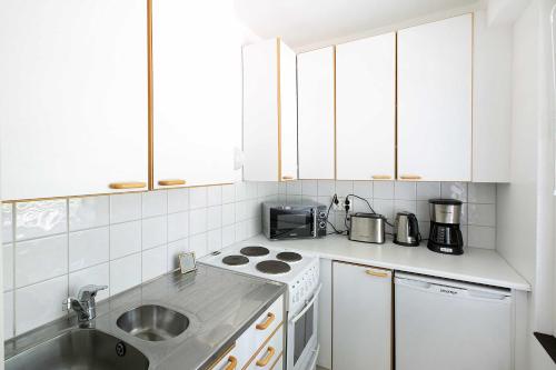 a kitchen with a sink and a stove top oven at Studio Ailos in Naantali