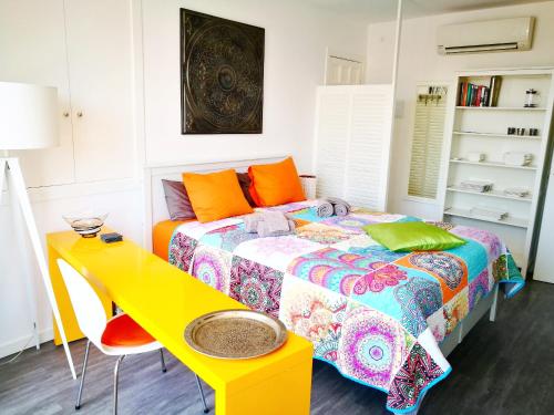 シッチェスにあるUnique studio Apartment with amazing terrace Sitges centre beachのベッドルーム1室(ベッド1台、黄色いテーブル付)