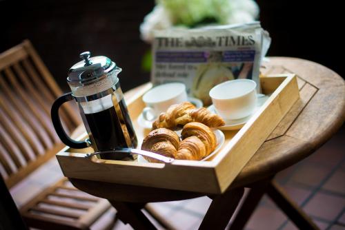 a tray of pastries sitting on a table with a coffee pot at 9 Hertford Street - 4 Stars VisitEngland in London