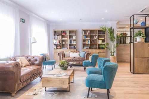een woonkamer met leren banken en blauwe stoelen bij BYPILLOW Velázquez 45 in Madrid