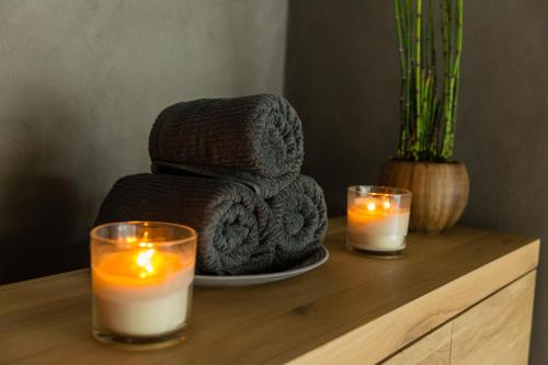 a table with two candles and a pile of towels at Hotel Boutique & Spa Las Mimosas Ibiza in San Antonio Bay