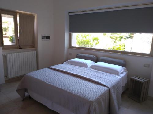 a bedroom with a bed with a large window at Pignarè in Locorotondo