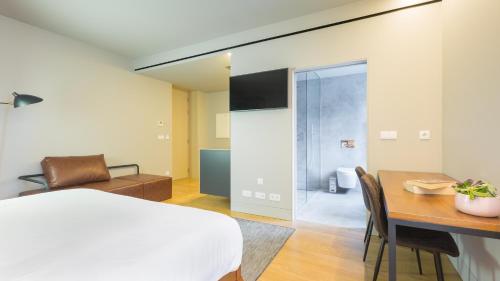 a bedroom with a bed and a desk and a table at Braga Heritage Lofts in Braga